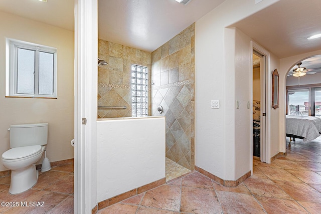 bathroom featuring a shower, toilet, and ceiling fan