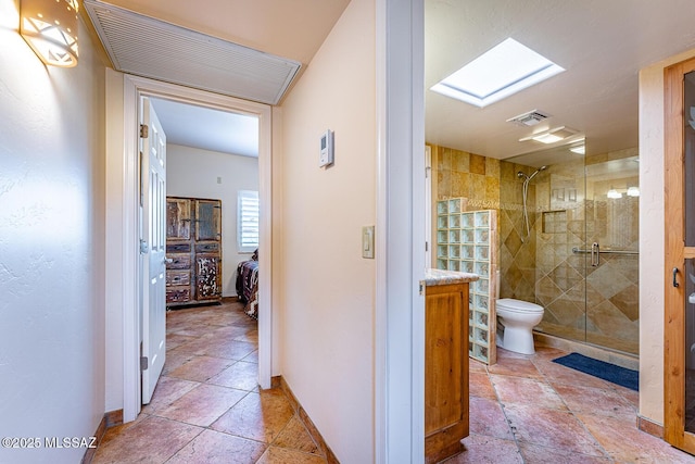 bathroom featuring toilet and walk in shower