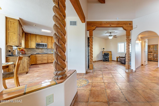 kitchen featuring decorative backsplash, ceiling fan, light tile patterned floors, and beam ceiling