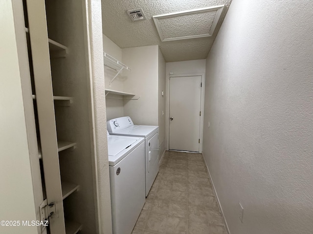 clothes washing area with a textured ceiling and independent washer and dryer