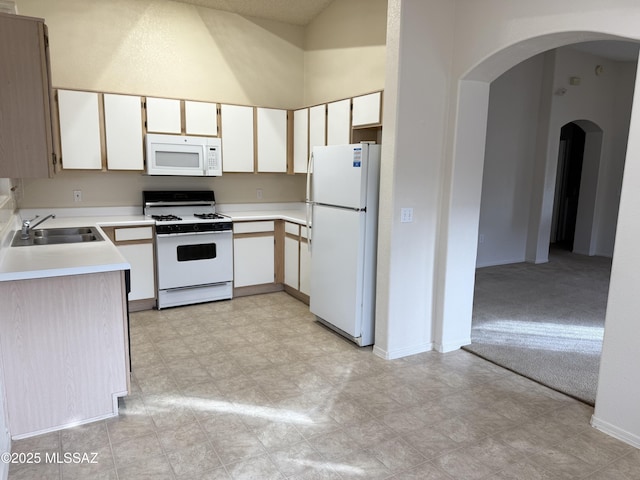 kitchen with white cabinets, light colored carpet, white appliances, and sink