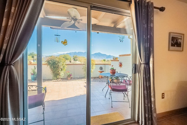 doorway to outside featuring tile patterned floors, a mountain view, and ceiling fan