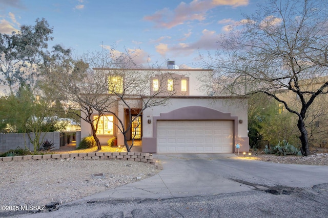 view of front of home with fence, a chimney, stucco siding, concrete driveway, and a garage