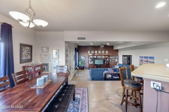 dining space featuring visible vents, a notable chandelier, and concrete floors