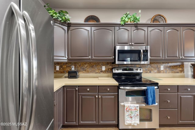 kitchen featuring tasteful backsplash, stainless steel appliances, and light countertops