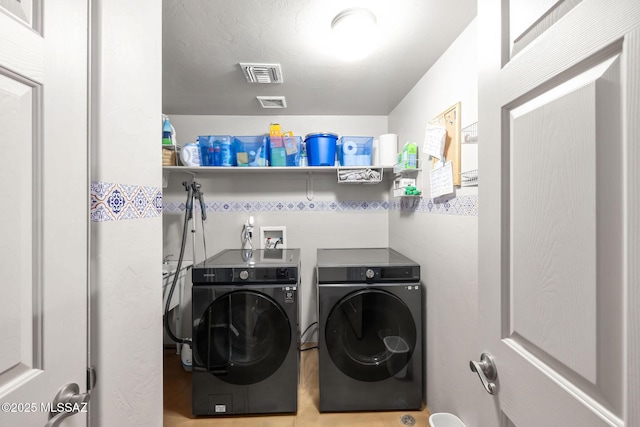 laundry area featuring visible vents, washer and dryer, and laundry area