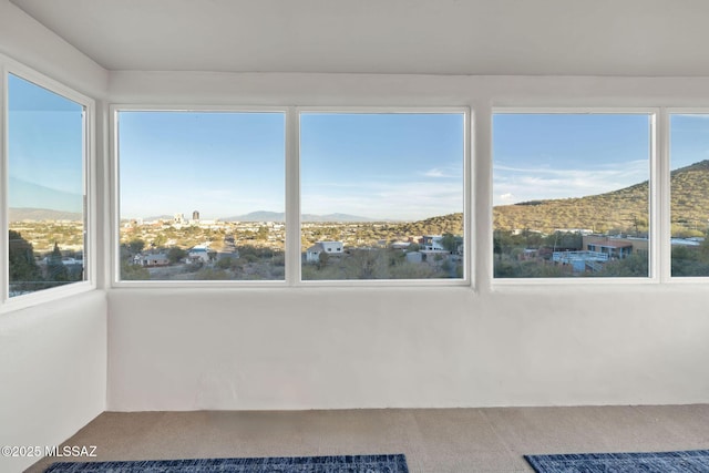 unfurnished sunroom featuring a mountain view