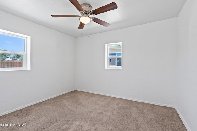 carpeted spare room featuring ceiling fan