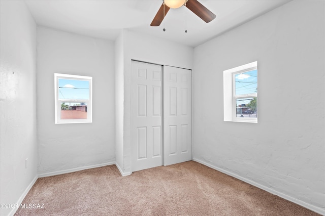 unfurnished bedroom featuring ceiling fan, a closet, and carpet