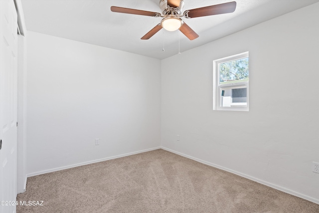 spare room featuring light carpet and ceiling fan