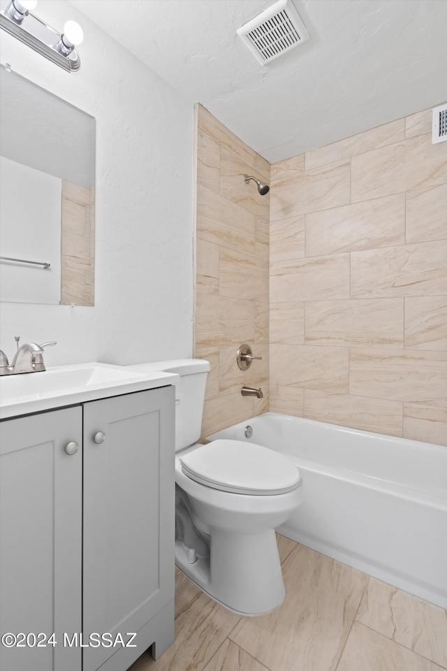 full bathroom with vanity, toilet, tiled shower / bath combo, and a textured ceiling