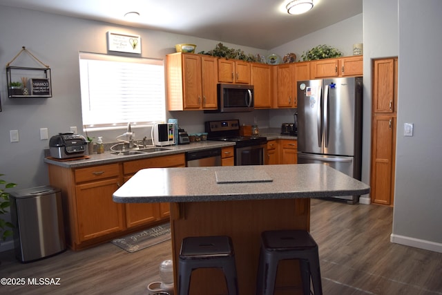 kitchen featuring a center island, lofted ceiling, a kitchen breakfast bar, dark hardwood / wood-style floors, and stainless steel appliances