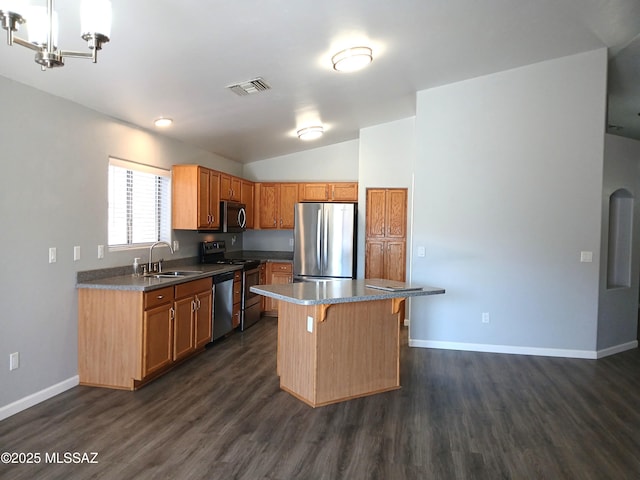 kitchen featuring a center island, visible vents, appliances with stainless steel finishes, a sink, and a kitchen breakfast bar