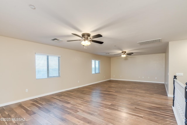 spare room with hardwood / wood-style flooring, plenty of natural light, and ceiling fan