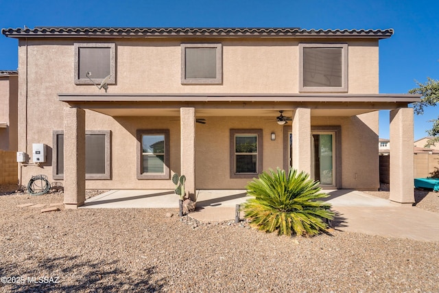 rear view of property featuring ceiling fan and a patio