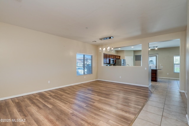 unfurnished living room featuring light wood-type flooring and plenty of natural light