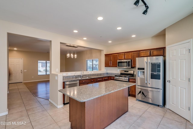 kitchen featuring hanging light fixtures, light tile patterned flooring, sink, and appliances with stainless steel finishes