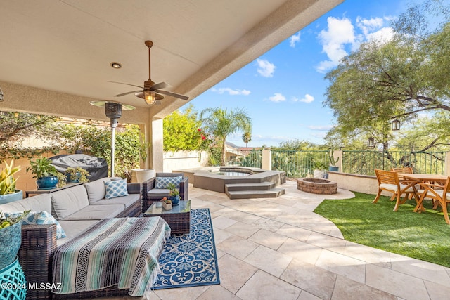 view of patio with an outdoor hot tub, ceiling fan, and an outdoor living space