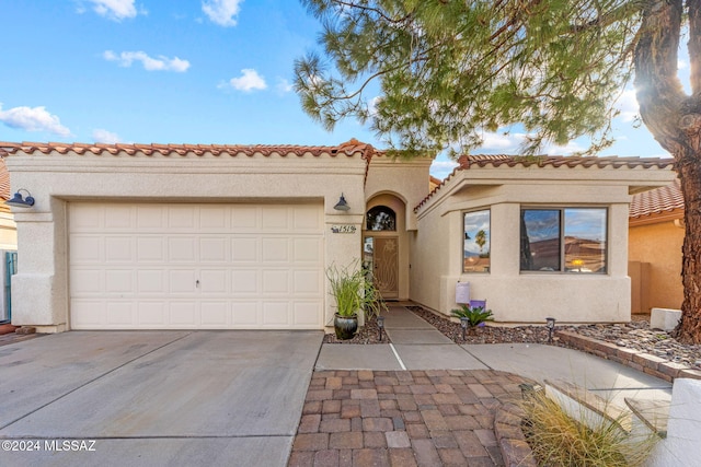 mediterranean / spanish-style home with a garage