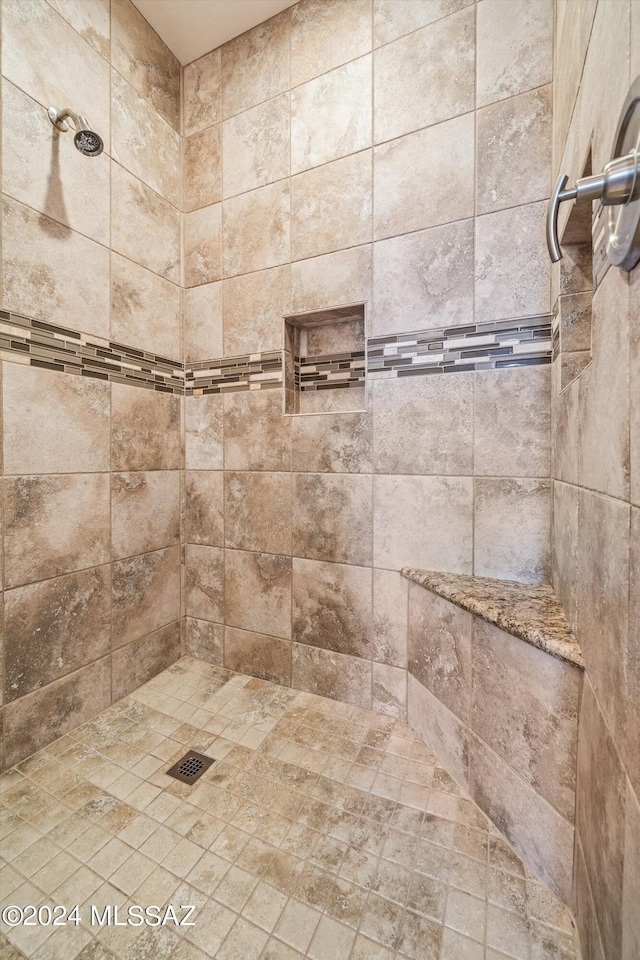 interior details featuring a tile shower