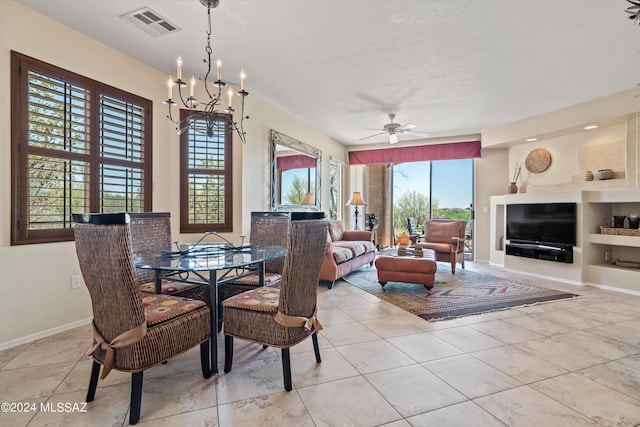 dining area with ceiling fan with notable chandelier and built in shelves