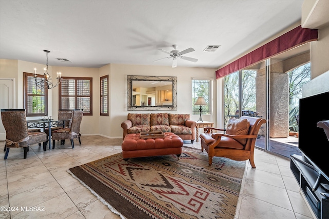 tiled living room with ceiling fan with notable chandelier