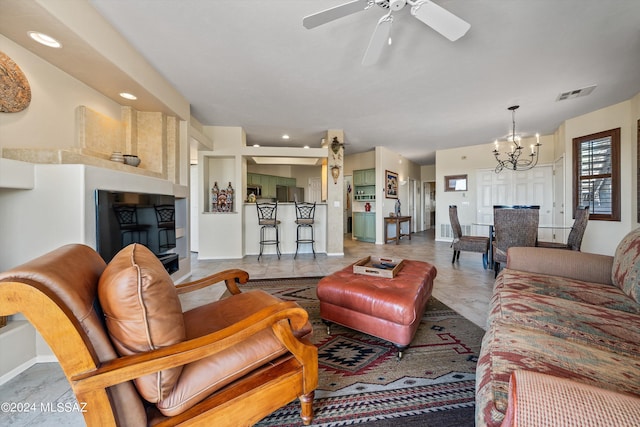 living room with ceiling fan with notable chandelier