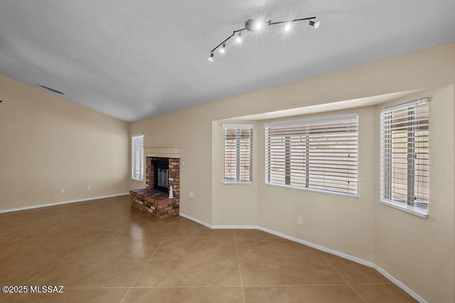 unfurnished living room featuring a fireplace and light tile patterned flooring