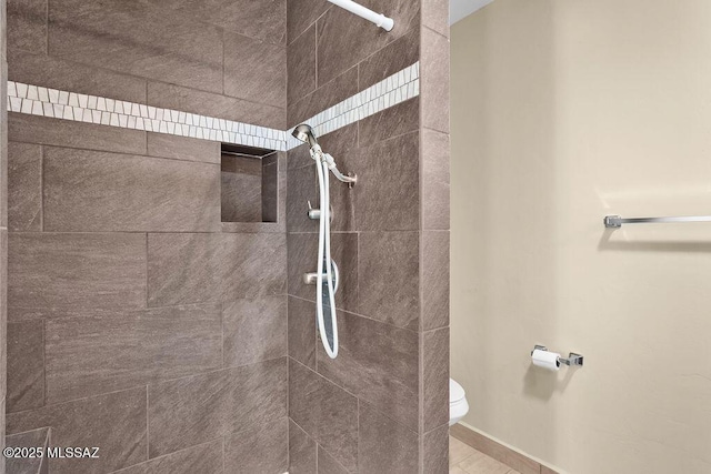 bathroom with tiled shower and toilet