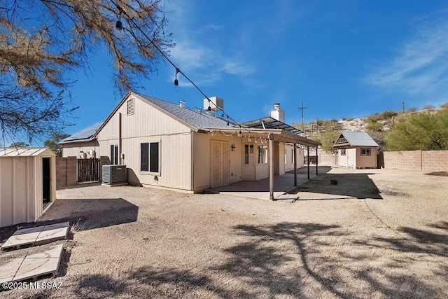 back of house with a patio, a storage unit, and cooling unit