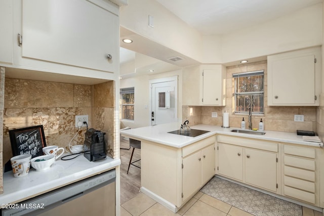 kitchen with light tile patterned flooring, sink, stainless steel dishwasher, kitchen peninsula, and black electric stovetop