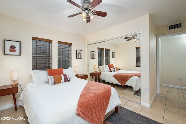 bedroom featuring light tile patterned flooring, ceiling fan, and a closet