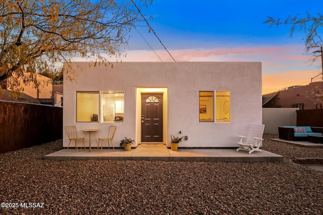 back house at dusk with a patio