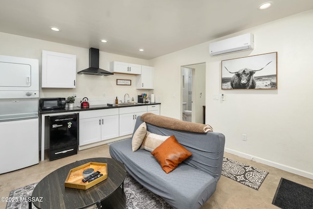 kitchen with a wall mounted AC, wall chimney range hood, white cabinets, and black appliances