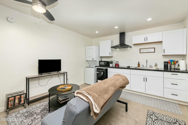 kitchen with white cabinetry, beverage cooler, sink, and wall chimney range hood