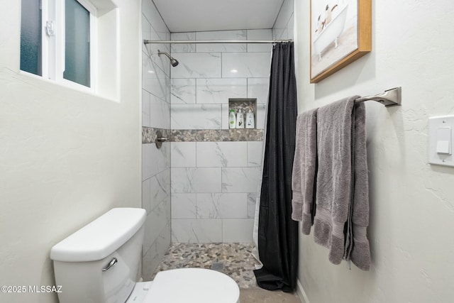 bathroom featuring a shower with curtain and toilet