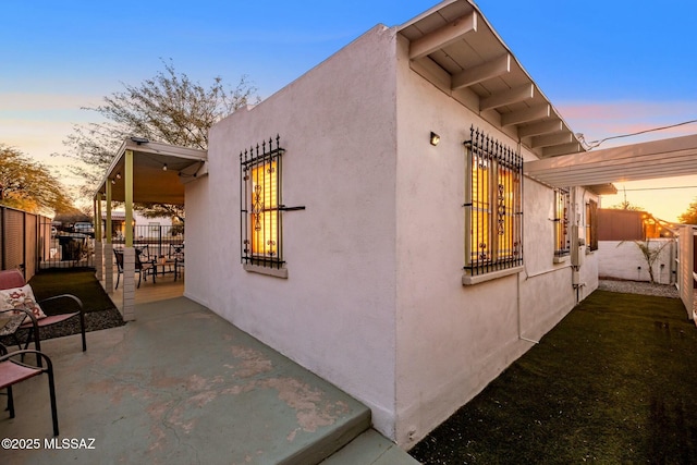 property exterior at dusk with a patio