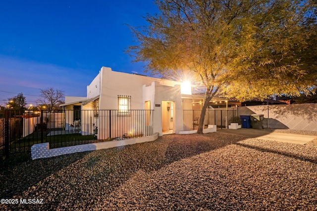 back house at dusk featuring a patio