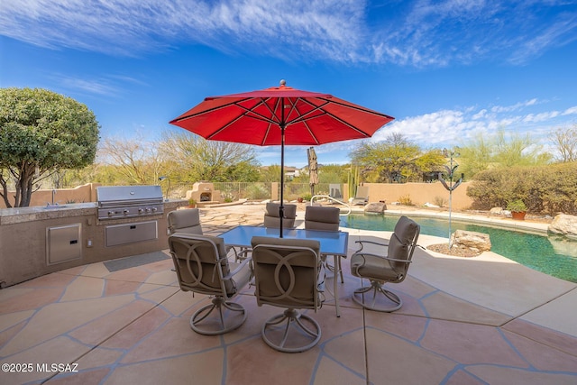 view of patio with a fenced in pool, grilling area, an outdoor kitchen, and a fireplace