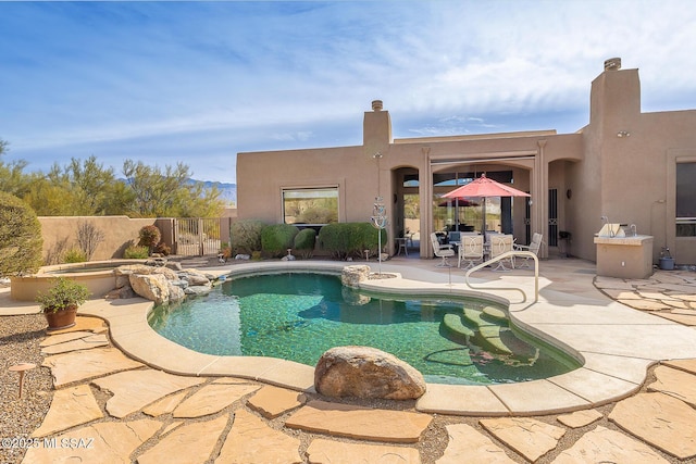 view of swimming pool featuring a patio area and an in ground hot tub