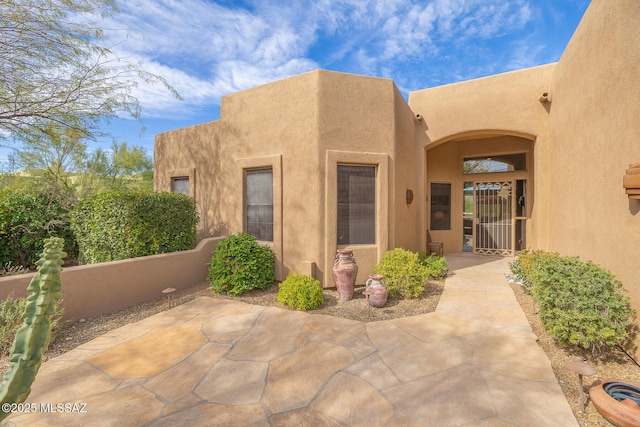 view of exterior entry with a patio area