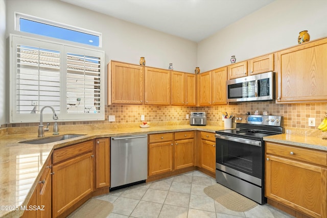 kitchen featuring a wealth of natural light, tasteful backsplash, stainless steel appliances, and a sink