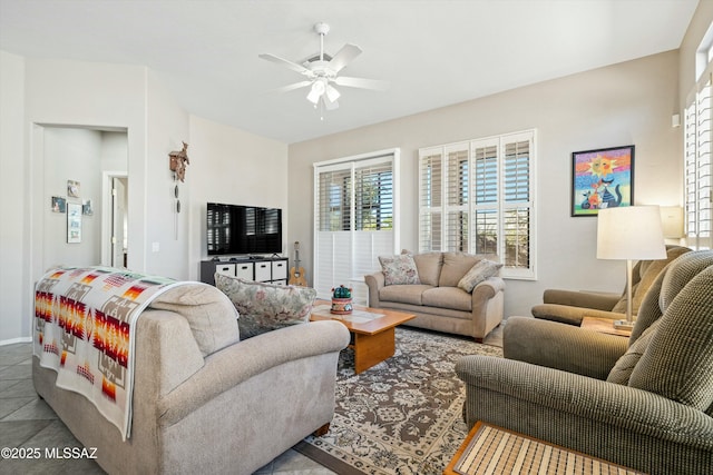 living room with ceiling fan and tile patterned flooring