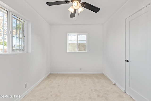 spare room featuring baseboards and light carpet