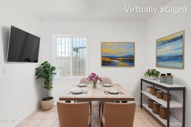 dining space featuring light tile patterned flooring and baseboards