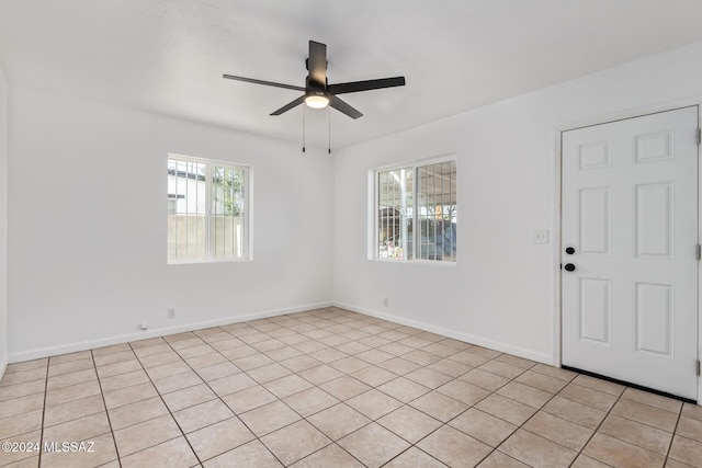 unfurnished room with a ceiling fan and baseboards