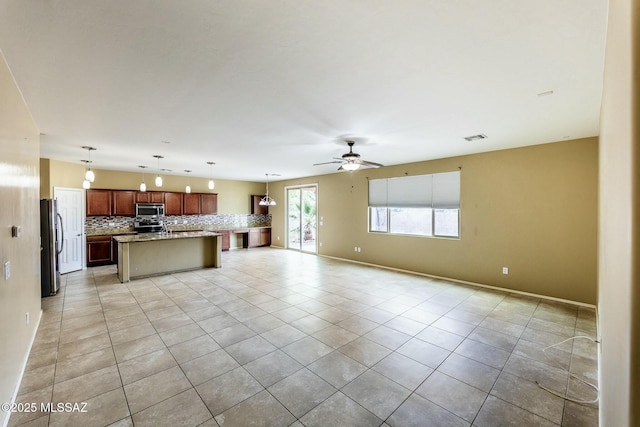 unfurnished living room featuring ceiling fan and light tile patterned floors