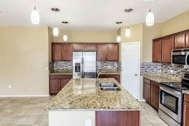 kitchen featuring decorative light fixtures, sink, a kitchen island with sink, stainless steel appliances, and light stone countertops