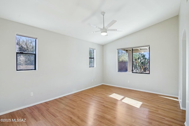 empty room featuring hardwood / wood-style flooring, vaulted ceiling, and ceiling fan