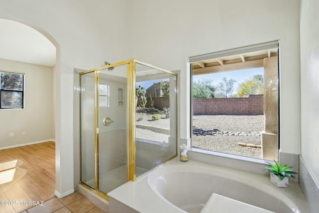 11215 N Via Rancho Naranjo, Oro Valley, AZ 85737 - bathroom featuring a bath, wood finished floors, a stall shower, and a healthy amount of sunlight
